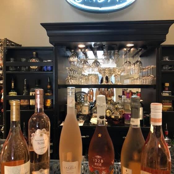 A bar with several bottles of wine on the counter.