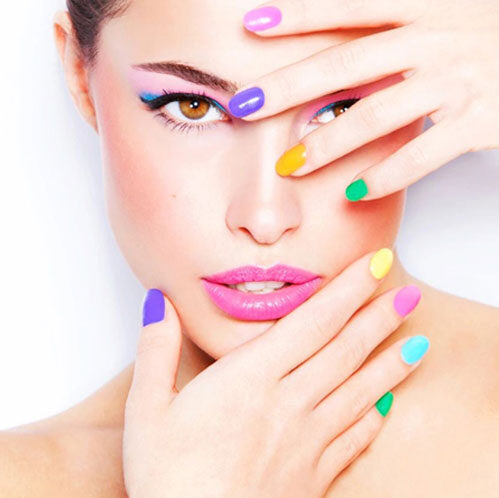 A woman with colorful nails and pink lipstick.